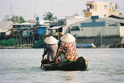 People working on boat sailing in river