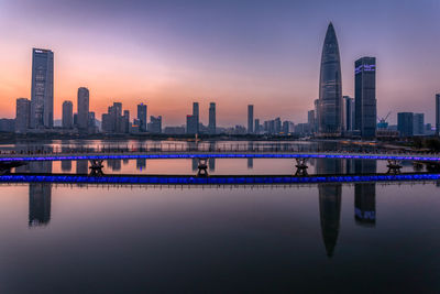 Reflection of buildings in city at sunset