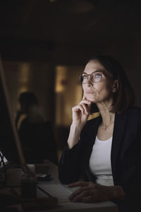 Mature businesswoman with eyeglasses working on computer at work place