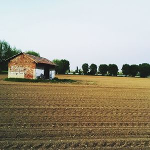 House on field against clear sky