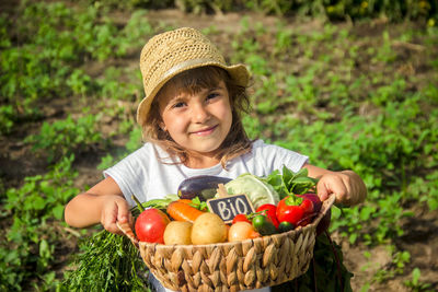 Portrait of smiling young woman holding fruits in basket