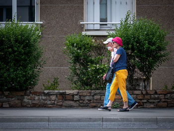 Full length of man standing on sidewalk against building