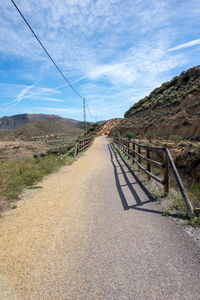 Road leading towards mountain against sky