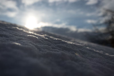 Close-up of snow against sky during sunset