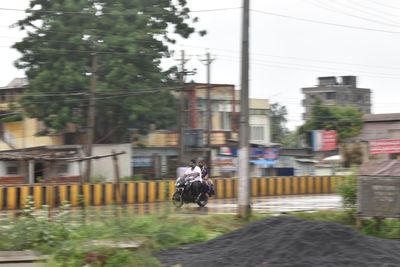 People walking on street amidst buildings in city