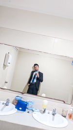 Portrait of young man standing in bathroom