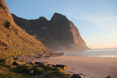 Tranquil sandy beach against rocky cliffs