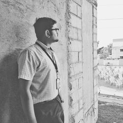 Side view of thoughtful man leaning on wall