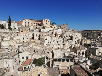 Buildings in town against clear blue sky