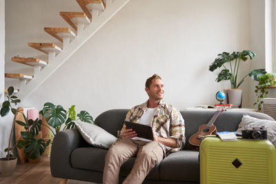 Portrait of senior man sitting on sofa at home