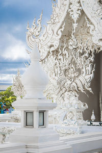 Close-up of buddha statue against sky