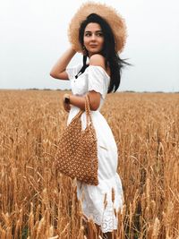 Portrait of young woman standing in field