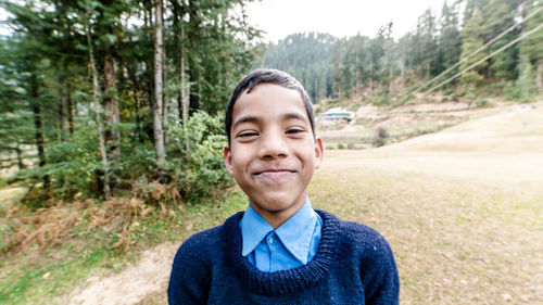 Portrait of smiling young woman standing on land