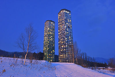 Built structure on snow covered field against clear blue sky