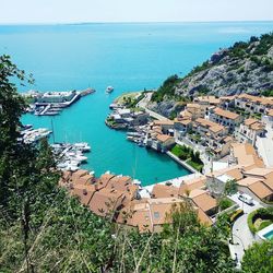 High angle view of townscape by sea against sky