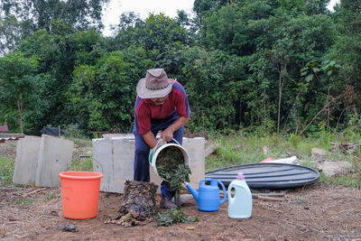 Man standing by plants against trees