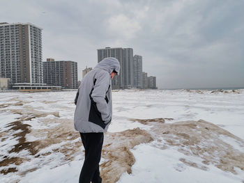 Rear view of man standing on snow