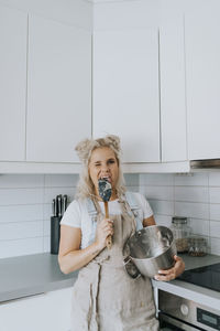 Smiling woman licking spatula