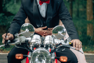 Midsection of man holding motorcycle