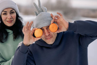 Happy couple playing winter game in forest outdoors. girlfriend with boyfriend fool around 