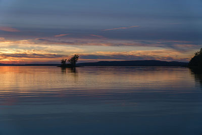 Silhouette boat in lake against sky during sunset