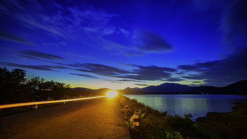 Scenic view of road against blue sky at sunset