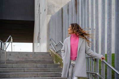 Rear view of woman sitting on staircase