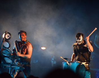 Friends standing on illuminated stage at night