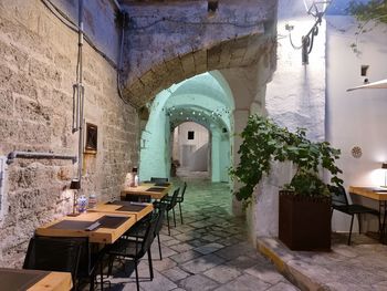 Empty chairs and tables against building