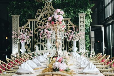 Vases on dining table amidst chairs