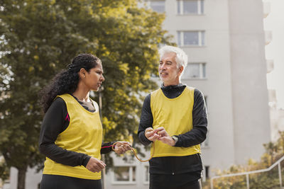 Visually impaired woman preparing for jogging with guide runner