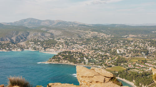 High angle view of townscape by sea against sky