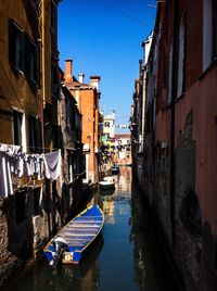 Canal amidst buildings in city against sky