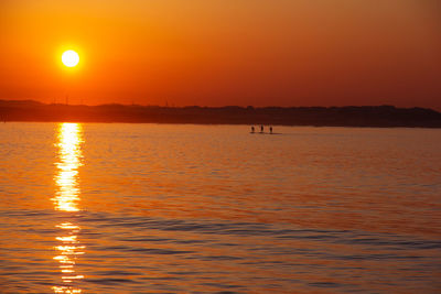 Scenic view of sea against orange sky