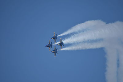 Low angle view of airplane flying against blue sky
