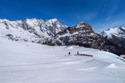 People skiing on snowcapped mountain against sky