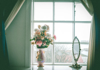 Close-up of flower vase on window sill