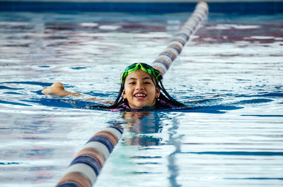 Portrait of smiling woman swimming in pool