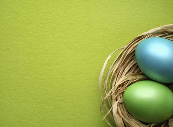 Close-up of easter eggs in basket on green background