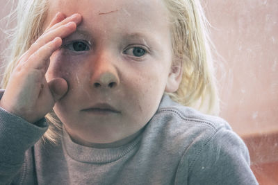 Close-up of boy looking through window