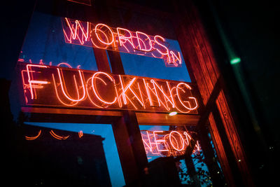 Low angle view of illuminated sign at night