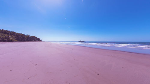 Scenic view of beach against blue sky