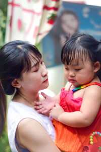 Mother kissing daughter at home