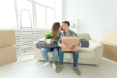 Young woman using phone while sitting at home