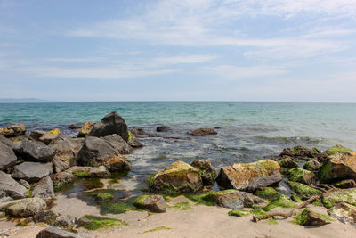 Rocks on sea shore against sky