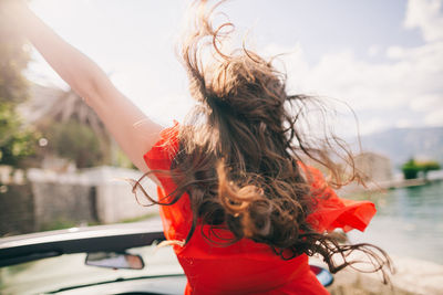 Rear view of young woman on boat against river