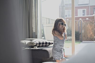 Young woman sitting by window at home