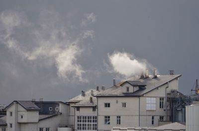 Low angle view of smoke emitting from chimney against sky