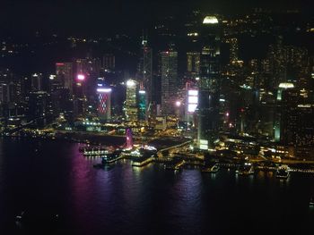 Illuminated buildings by river at night