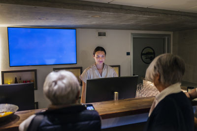 Receptionist assisting customer at health spa